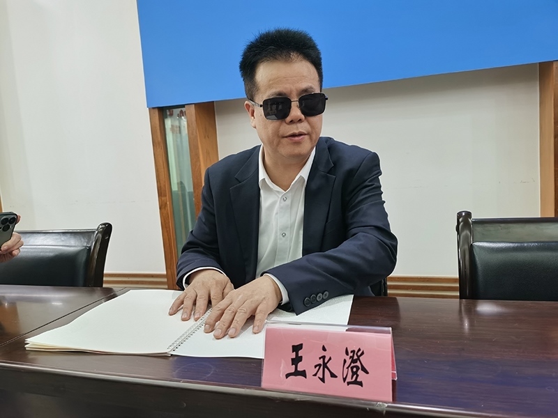 全國人大代表王永澄正在閱讀盲文版代表建議答復(fù)。本報(bào)記者 張 璁?dāng)z