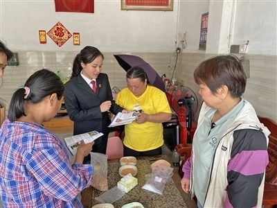  圖⑤：龍圩區(qū)法院法官到群眾家中開展法治宣傳。資料圖片