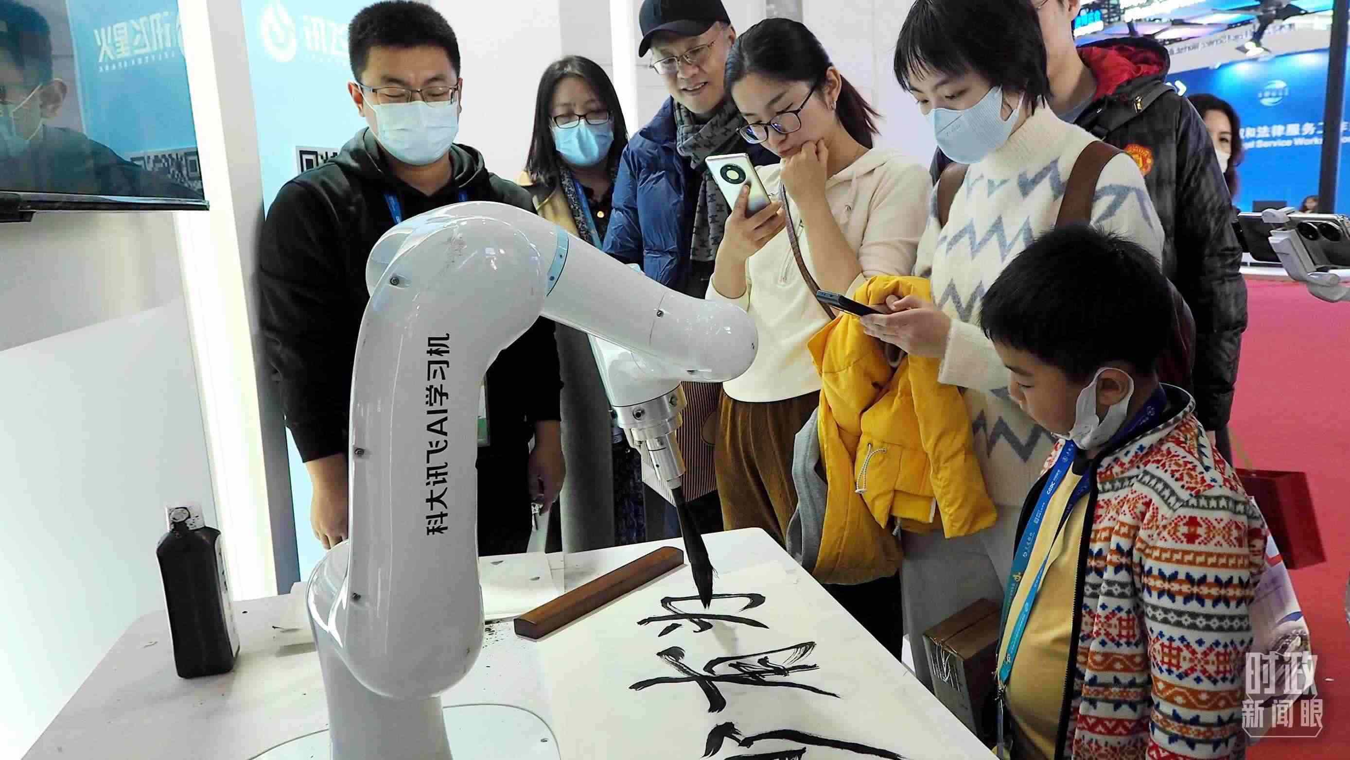 △觀眾在首屆鏈博會上體驗AI書法機器人。
