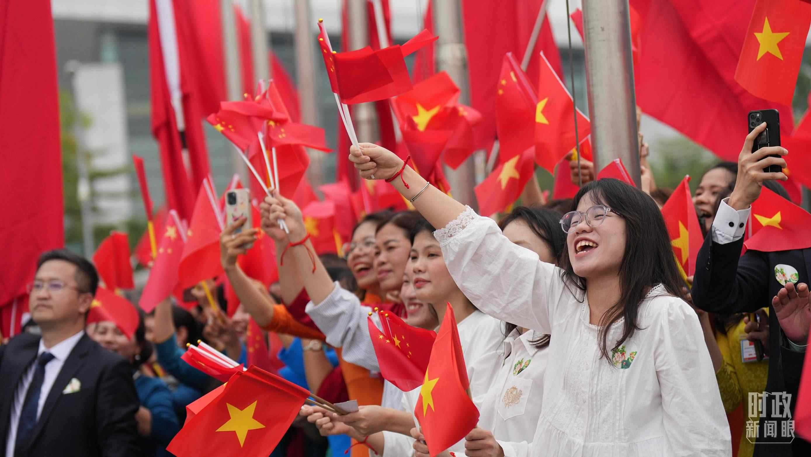 △人們揮舞兩國旗幟歡迎習(xí)近平訪越。（總臺國廣記者李晉拍攝）
