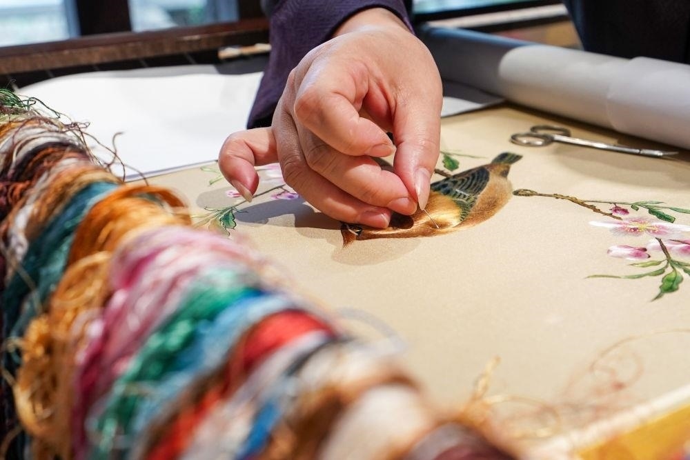 △2023年7月6日，盧建英在江蘇蘇州平江路的工作室內(nèi)刺繡。