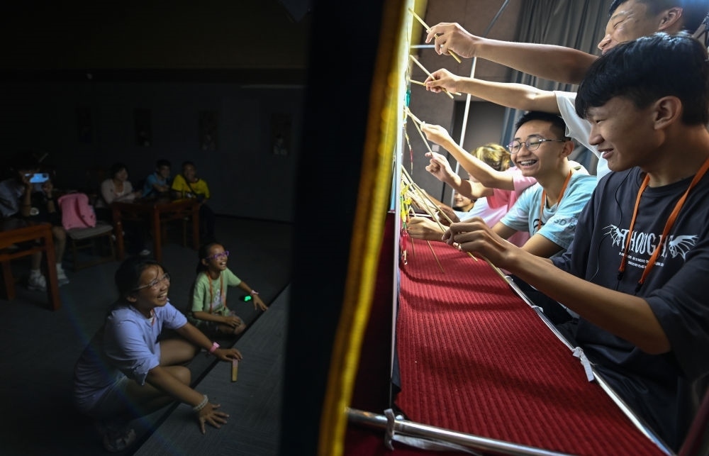 2023年8月8日，進行暑期研學(xué)的學(xué)生在位于陜西省西安市的中國秦腔藝術(shù)博物館體驗皮影戲演出。新華社記者 鄒競一 攝