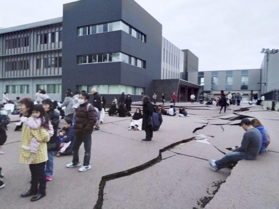  1月1日，在日本石川縣輪島市，人們站在被地震破壞的地面上。新華社/共同社