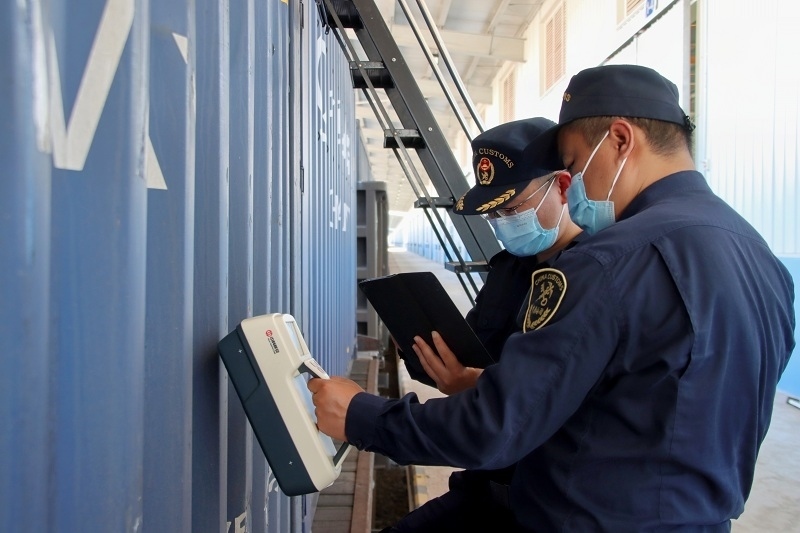 海關(guān)關(guān)員使用手持式輻射探測儀對中老鐵路入境貨物進(jìn)行檢測。張釋巍攝