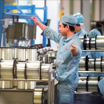 在位于武漢的長飛光纖光纜股份有限公司光纖生產(chǎn)車間內(nèi)，工作人員對光纖進行檢測（資料圖片）。肖藝九攝/本刊