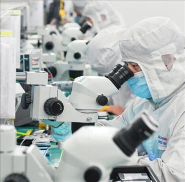 在位于武漢中國光谷的光電器件研發(fā)制造商——武漢光迅科技股份有限公司生產(chǎn)車間內(nèi)，技術(shù)人員在光模塊生產(chǎn)線作業(yè)（2023年4月11日攝）。程敏攝/本刊