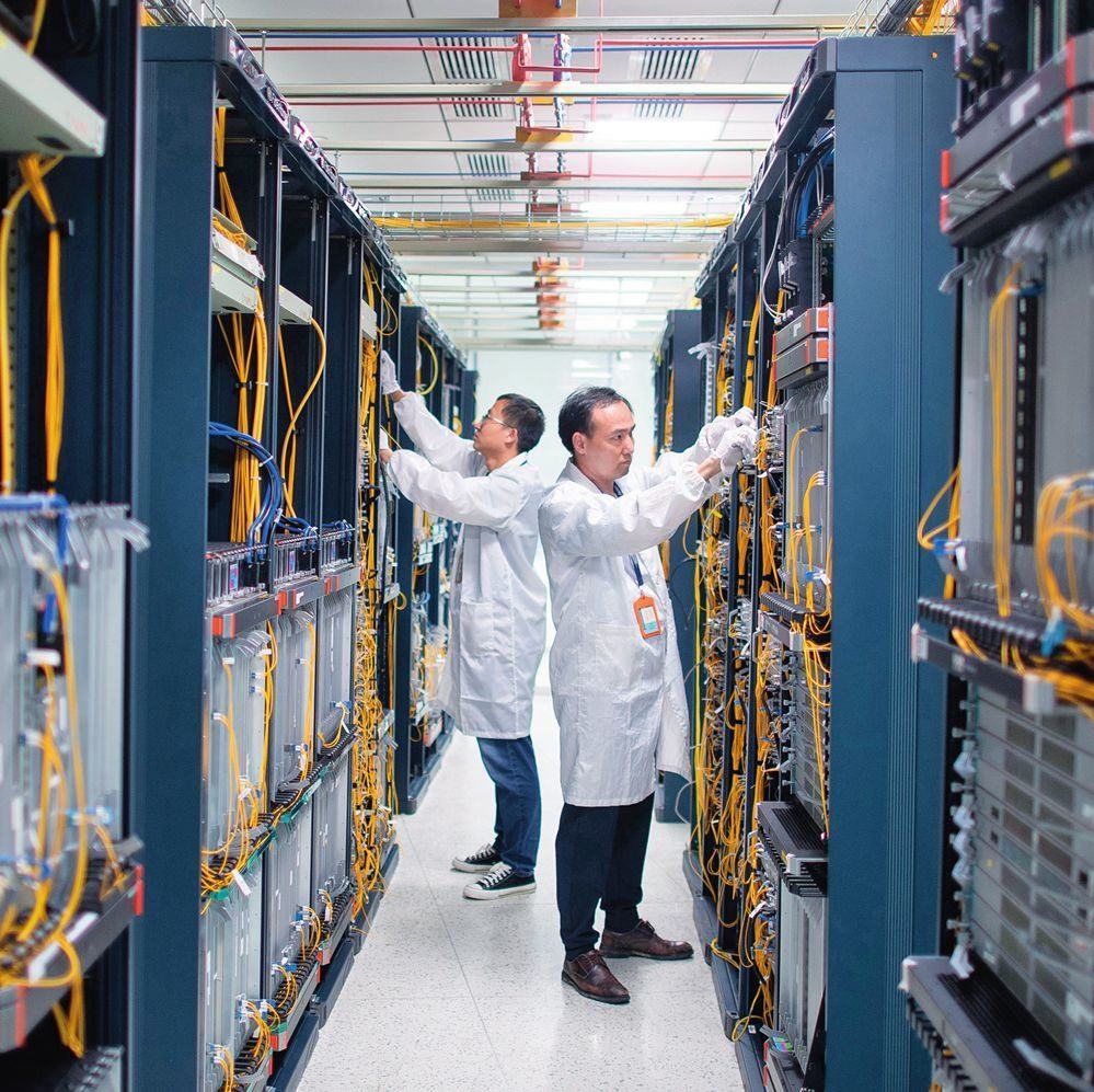 在位于武漢中國光谷的光電器件研發(fā)制造商——武漢光迅科技股份有限公司生產(chǎn)車間內(nèi)，技術(shù)人員在光模塊生產(chǎn)線作業(yè)（2023年4月11日攝）。程敏攝/本刊