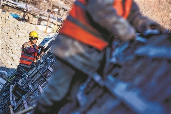 1月3日，房山區(qū)，工人正在雙泉河修筑堤壩。