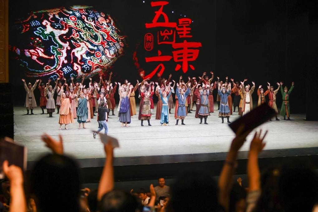 2023年7月31日，新疆和田地區(qū)新玉歌舞團在烏魯木齊京劇院演出舞劇《五星出東方》后和觀眾互相揮手致意。這場演出是第六屆中國新疆國際民族舞蹈節(jié)的參演劇目之一，曾榮獲國家“文華獎”等。新華社記者 郝昭 攝