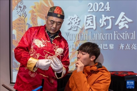 1月28日，在上海豫園舉行的民俗活動上，美國馬斯卡廷中學學生在非遺傳承人的指導下吹糖偶。 新華社記者 王翔 攝