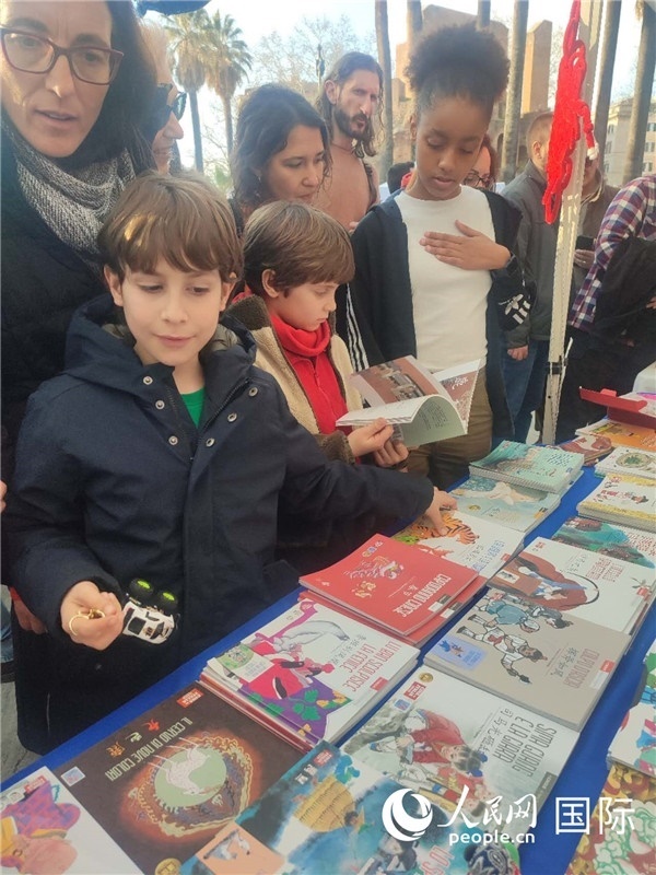 印刷精美的中國(guó)傳統(tǒng)文化叢書吸引了小游客的注意。人民網(wǎng)記者鄭彬攝