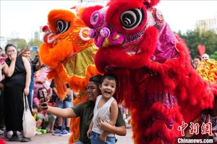 圖為舞獅表演吸引民眾合影。張興龍攝