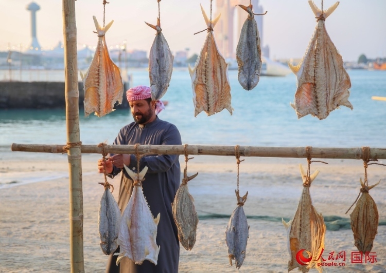  手工藝者展示如何晾曬魚干。人民網(wǎng) 塔里克·易卜拉欣攝