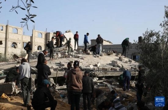  3月3日，在加沙地帶南部城市拉法，人們查看被以軍空襲破壞的建筑。新華社發(fā)（哈立德·奧馬爾攝）