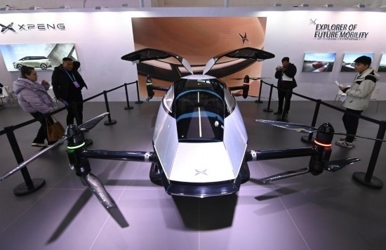 2023年12月1日，在鏈博會(huì)智能汽車鏈展區(qū)小鵬汽車展臺(tái)，參觀者觀看一臺(tái)智能飛行器。新華社記者蔡湘鑫攝