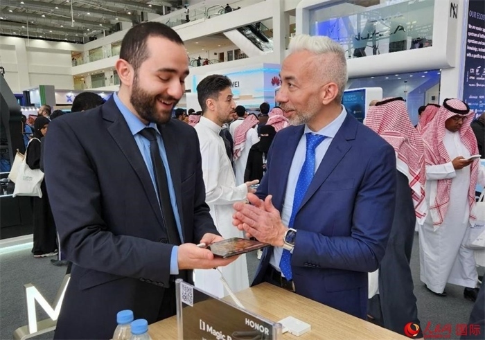 兩名觀眾在榮耀手機(jī)展臺(tái)前交流。人民網(wǎng)記者 管克江攝