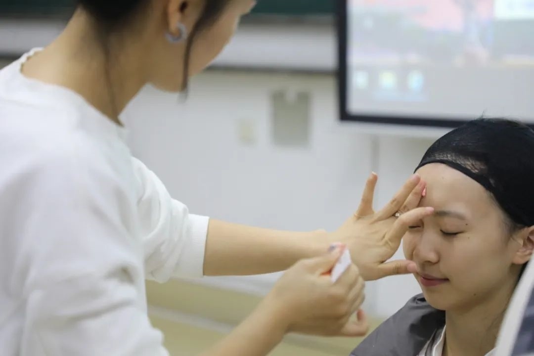 課堂上，一名學生在體驗上戲妝。學校供圖