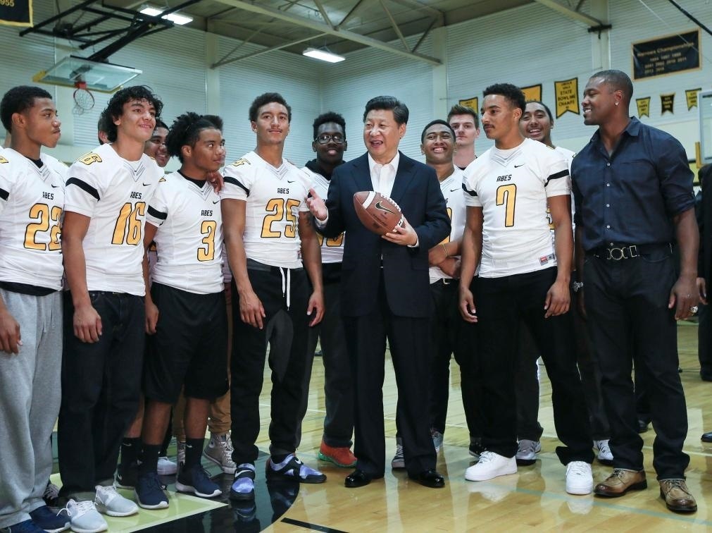 2015年9月23日，國家主席習(xí)近平參觀美國塔科馬市林肯中學(xué)。這是習(xí)近平在學(xué)校體育館，同上橄欖球訓(xùn)練課的學(xué)生們親切交談。新華社記者 蘭紅光 攝