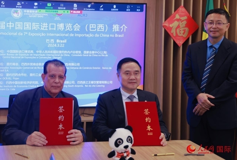 巴西外貿(mào)商會(huì)聯(lián)合會(huì)會(huì)長(zhǎng)阿代爾·羅伯托（左）與中國(guó)國(guó)際進(jìn)口博覽局副局長(zhǎng)吳政平（中）現(xiàn)場(chǎng)簽訂協(xié)議。人民網(wǎng)記者 宋亦然攝
