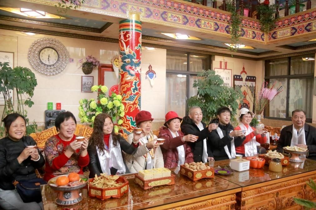 游客們?nèi)胱∶袼藓?，舉杯共飲酥油茶。新華社記者 邱星翔 攝