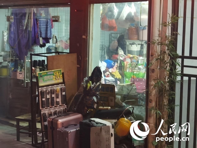 南寧“城中村”一裁縫鋪老板將電線從店內(nèi)拉出為電動自行車充電。人民網(wǎng) 覃心攝