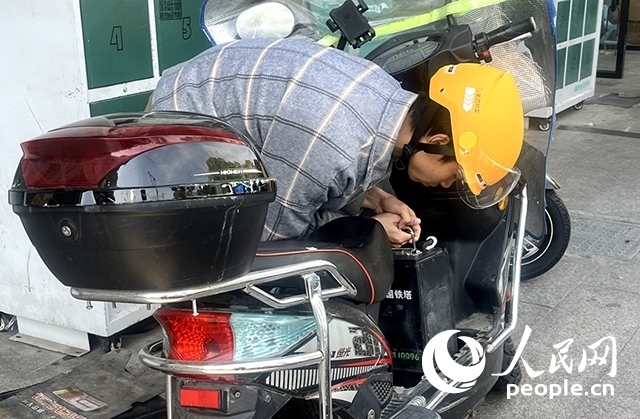 杭州一名外賣騎手正在更換共享電池。人民網(wǎng)記者 張麗瑋攝