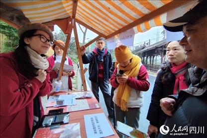 1月6日，“2024成都蒲江柑甜采摘節(jié)”上，記者見到了小萌（左一）和許多年輕人忙著做訪客接待、現(xiàn)場布置、票務核對、采摘服務等工作。人民網(wǎng)記者朱虹攝