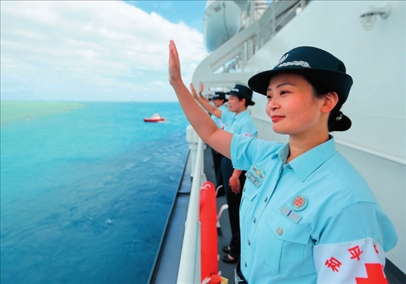 中國海軍“和平方舟”號醫(yī)院船結(jié)束訪問湯加時，任務(wù)官兵中的文職人員向歡送人群揮手告別（2023年8月4日攝）。徐巍攝/本刊