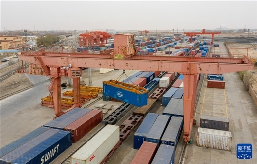 4月21日，二連浩特鐵路口岸龍門吊吊裝中歐班列集裝箱（無人機照片）。 新華社發(fā)（張海峰攝）