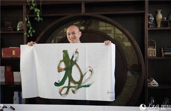 老撾駐華大使館三秘明君參加《五百筆·瀾湄合作》集體藝術(shù)創(chuàng)作。人民網(wǎng)王婧攝。