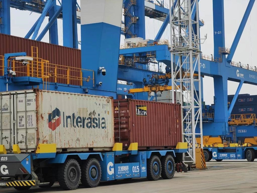 在欽州自動(dòng)化集裝箱碼頭，智能導(dǎo)引運(yùn)輸車在運(yùn)送集裝箱。新華社記者趙歡 攝