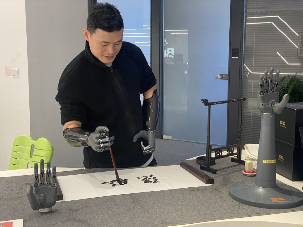 2024年3月29日，在浙江強(qiáng)腦科技有限公司展廳內(nèi)，失去雙手的產(chǎn)品體驗(yàn)官倪敏成依靠智能仿生手寫毛筆字。新華社記者 魏一駿 攝