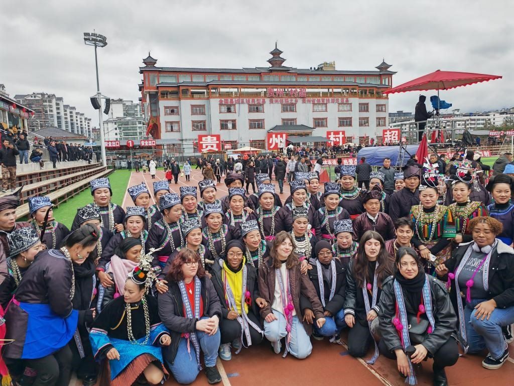 法國青年在“村超”賽場邊與參加表演的村民合影。新華社記者 羅羽 攝