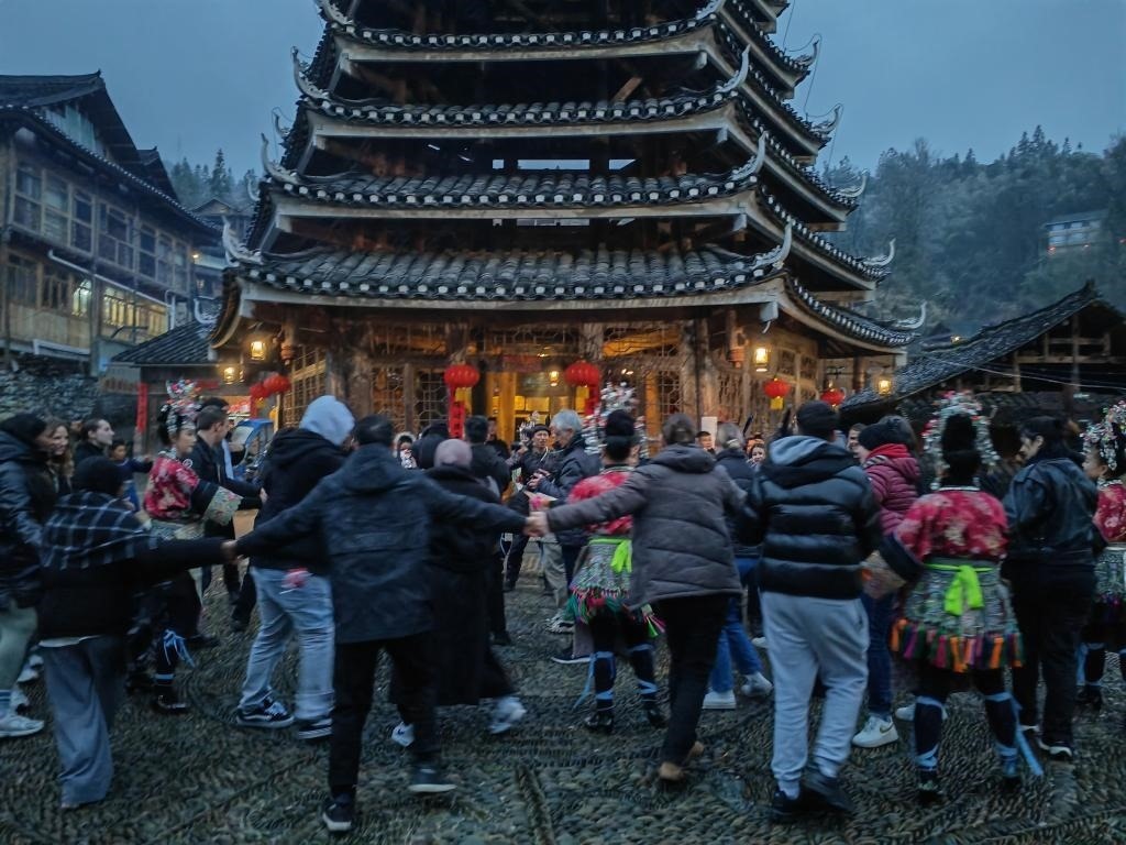 法國青年與當(dāng)?shù)卮迕駹渴痔?。新華社記者 羅羽 攝