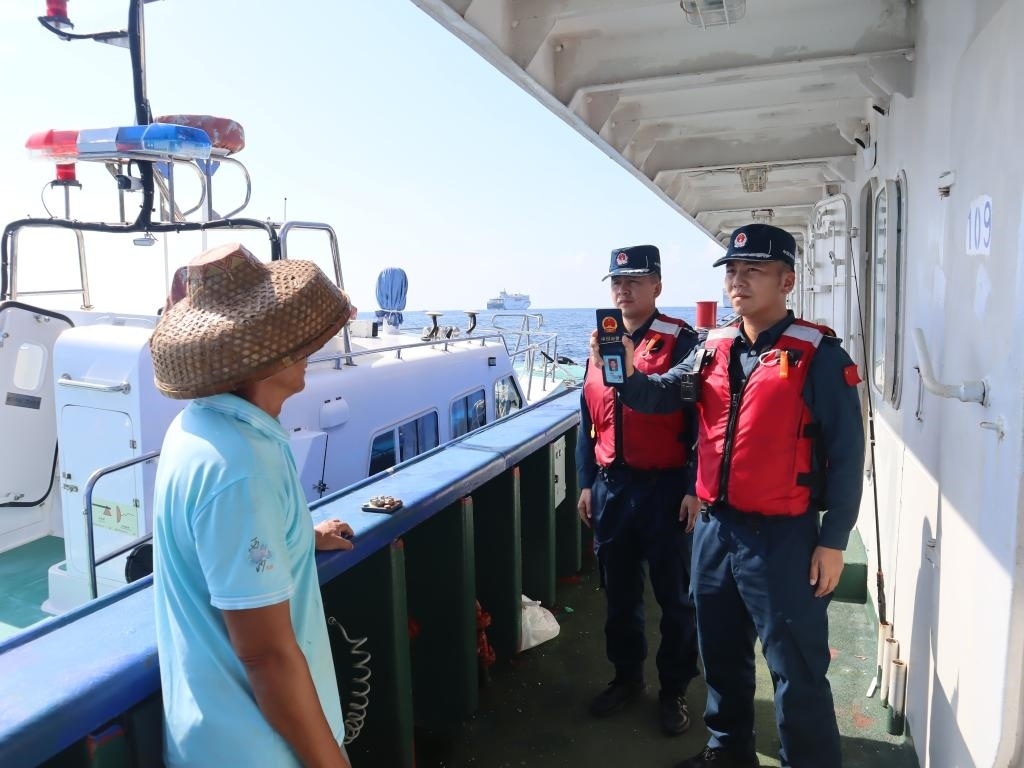 圖為5月12日海警執(zhí)法員登臨檢查漁船。（中國(guó)海警局南海分局供圖）
