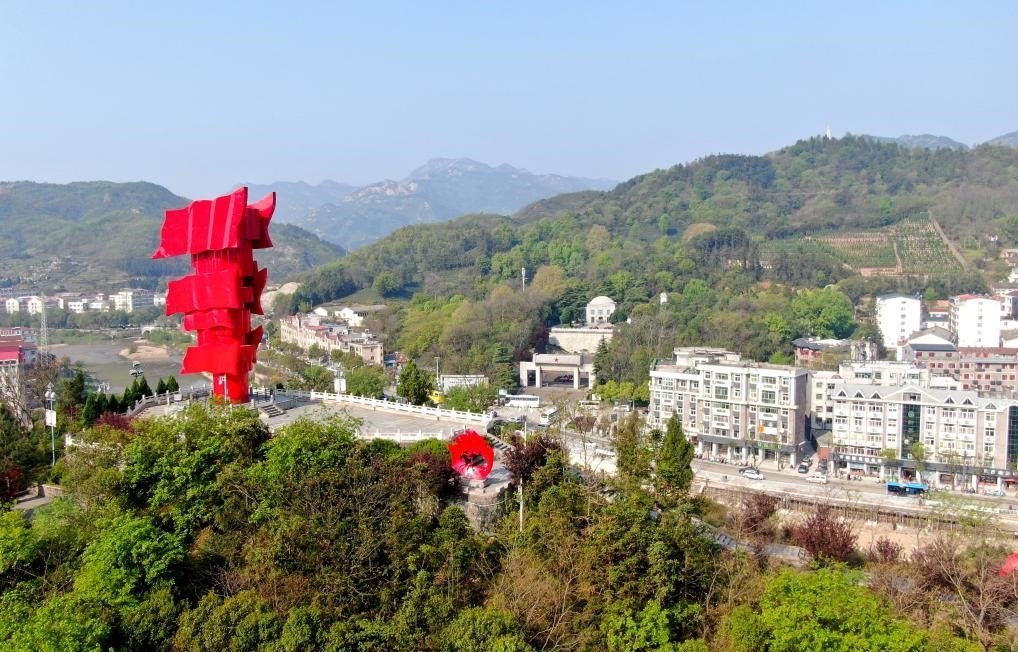 這是2021年4月9日拍攝的鄂豫皖蘇區(qū)首府革命博物館附近的英雄山上的“紅旗飄飄”主題雕塑（無人機照片）。新華社發(fā)
