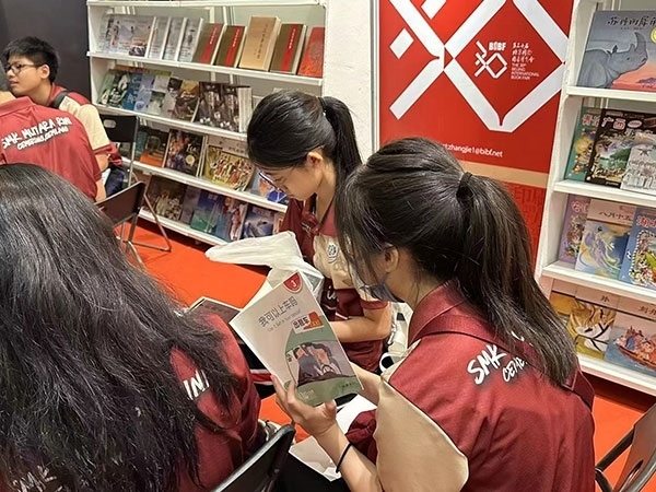 馬來西亞讀者在中國聯(lián)合展臺翻閱中國書籍。 中國圖書進(jìn)出口（集團(tuán)）有限公司供圖
