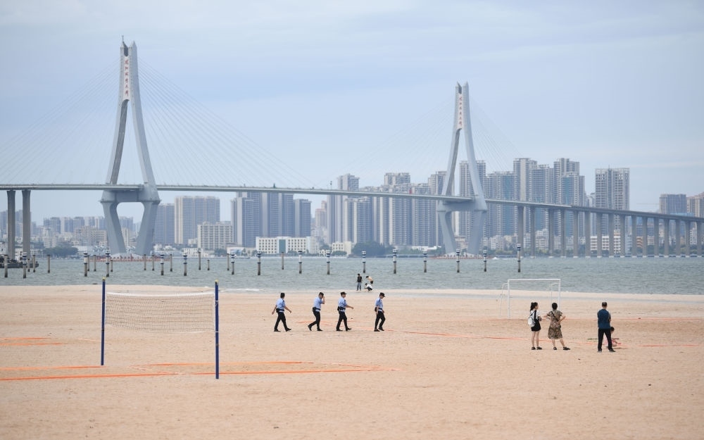 2023年7月17日，廣東湛江五環(huán)廣場的沙灘上，公安民警在執(zhí)勤巡邏。新華社記者 鄧華 攝
