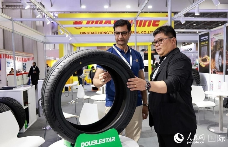 工作人員向客戶展示雙星電動汽車輪胎。和傳統(tǒng)汽車輪胎相比，電動汽車輪胎具有更高承載能力、更加靜音舒適、更好極速抓地、更低滾動阻力等特點。人民網(wǎng)記者 管克江攝