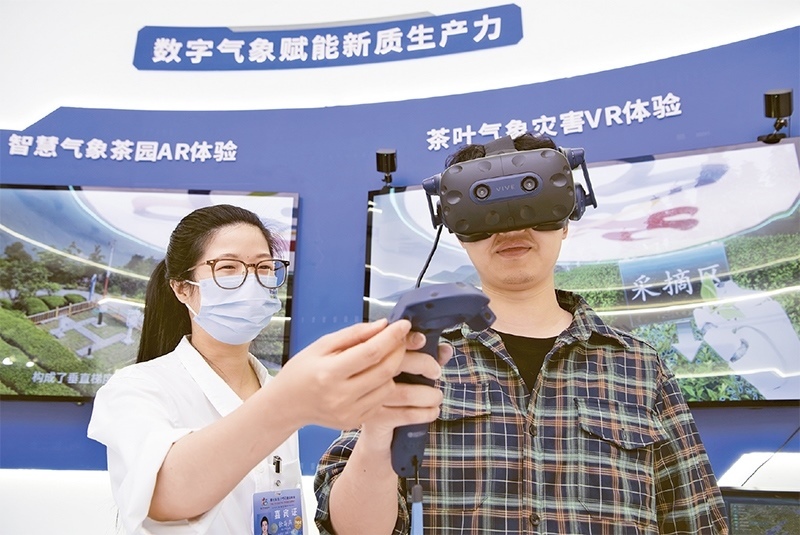 2024年5月23日，第七屆數(shù)字中國(guó)建設(shè)峰會(huì)現(xiàn)場(chǎng)體驗(yàn)區(qū)在福州海峽國(guó)際會(huì)展中心向?qū)I(yè)觀眾開放。本次現(xiàn)場(chǎng)體驗(yàn)區(qū)圍繞本屆峰會(huì)主題“釋放數(shù)據(jù)要素價(jià)值，發(fā)展新質(zhì)生產(chǎn)力”，設(shè)置“數(shù)字惠民”、“數(shù)字能力”、“數(shù)字基礎(chǔ)”、“數(shù)字生態(tài)”、“數(shù)字賦能”五大板塊。圖為一名觀眾（右）在數(shù)字氣象賦能新質(zhì)生產(chǎn)力展臺(tái)上進(jìn)行體驗(yàn)。 新華社記者 魏培全/攝