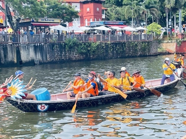 多元種族共同奮輯前進，體驗在馬六甲河劃龍舟，引來大批游客駐足圍觀。組委會供圖