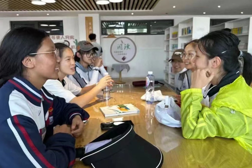 2023年7月10日，在果洛西寧民族中學，上海市大同中學學生（右）與果洛西寧民族中學學生交流。新華社發(fā)（果洛州教育局供圖）