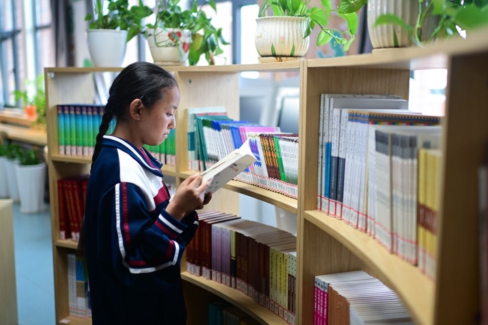 6月18日，果洛西寧民族中學(xué)學(xué)生尼東拉毛在圖書室看書。