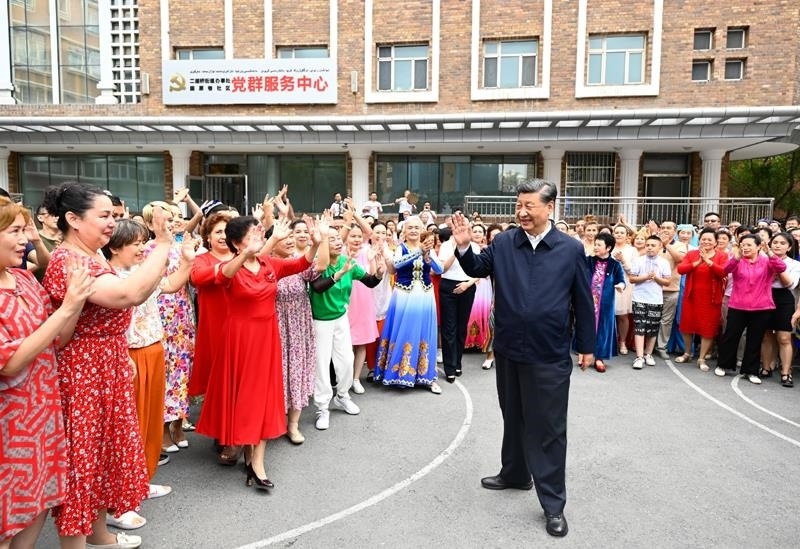 2022年7月13日，習(xí)近平總書(shū)記在新疆烏魯木齊市天山區(qū)固原巷社區(qū)考察時(shí)，向各族群眾揮手致意。