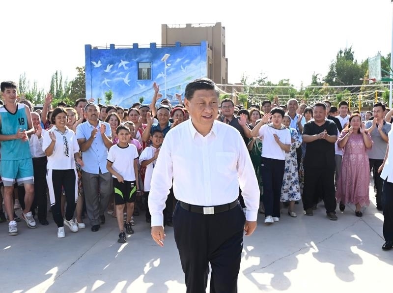 2022年7月14日，習(xí)近平總書(shū)記在新疆吐魯番市高昌區(qū)亞爾鎮(zhèn)新城片區(qū)新城西門(mén)村考察時(shí)，同各族群眾在一起。
