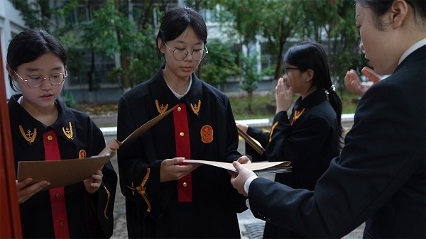 圖①：武平法院干警向學生分發(fā)道具卷宗。