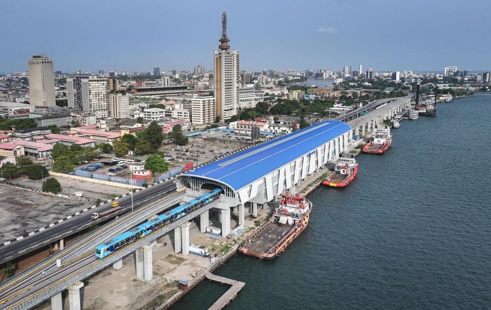 2024年3月2日，在尼日利亞拉各斯，一列輕軌藍(lán)線列車駛?cè)氪a頭站（無人機(jī)照片）。拉各斯輕軌藍(lán)線是西非地區(qū)首條由中國企業(yè)自主設(shè)計(jì)、建造、施工、運(yùn)營的電氣化城市軌道交通項(xiàng)目。新華社記者 韓旭 攝