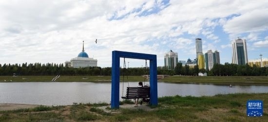 6月30日，一名女子在哈薩克斯坦首都阿斯塔納伊希姆河畔休息。新華社記者 王建華 攝