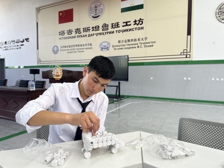 在塔吉克斯坦魯班工坊內(nèi)，學員正在操作能力源創(chuàng)新套件。本報記者 屈佩 攝