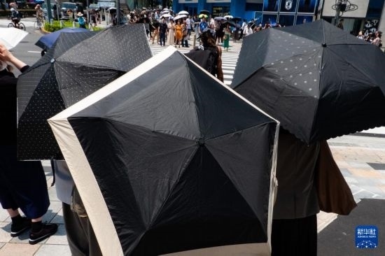 7月4日，人們?cè)谌毡緰|京原宿的街道上等待紅綠燈。新華社記者 張笑宇 攝